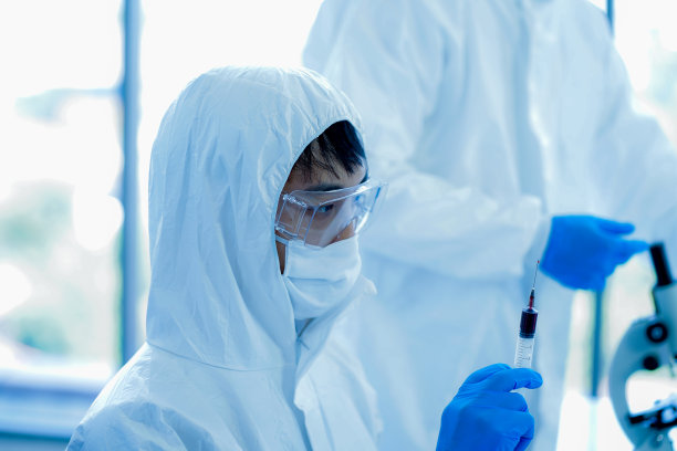 年轻的亚洲男性医学科学家穿着防护服、眼镜、面罩和连身衣，在临床实验室做试验样本图片下载