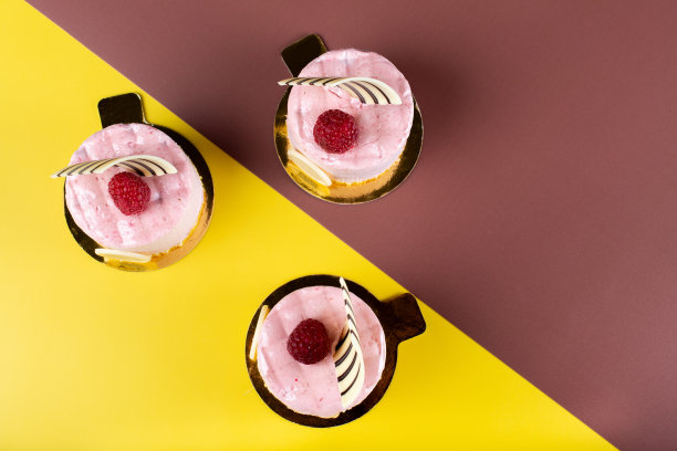 覆盆子香草和白巧克力慕斯甜点与标志空间隔离在黄色和棕色。图片下载