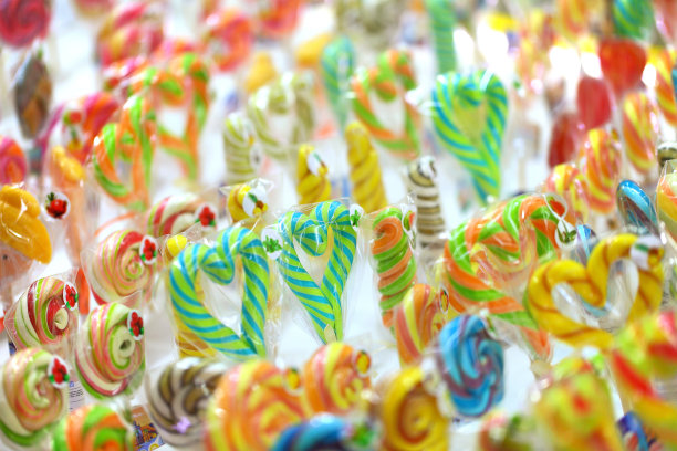 糖果在棒子上涂成心形和不同的形状。图片下载