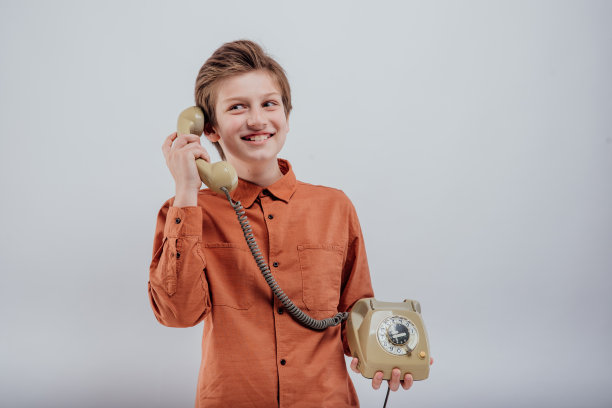 快乐的男孩在旧电话上聊天，孤立的白上图片下载