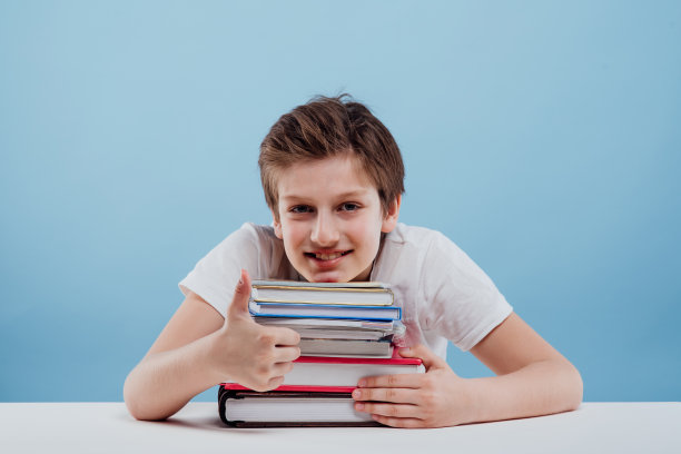 快乐的男孩翘着大拇指看着镜头，图片下载