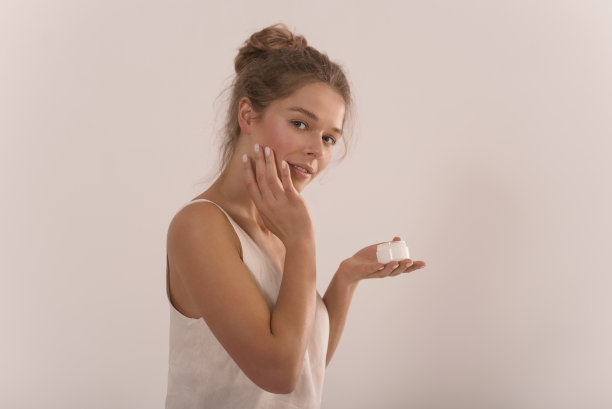 一个年轻迷人的快乐女人的肖像，手里拿着一罐奶油。图片下载