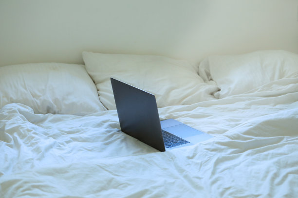 床上笔记本电脑，居家办公概念图片下载