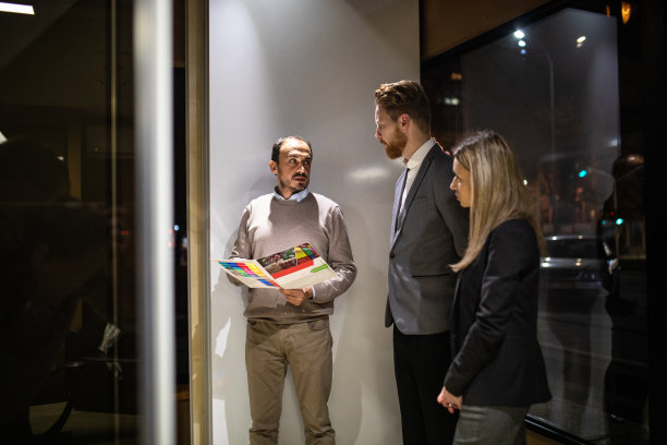 一对年轻夫妇在玻璃店里与售货员交谈图片下载