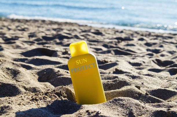 沙滩上的防晒乳液瓶子图片下载