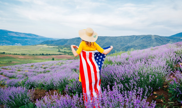 在薰衣草田里举着美国国旗的女人图片下载