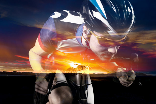 专业的自行车手骑在田野和橙色的夕阳天空背景。图片下载