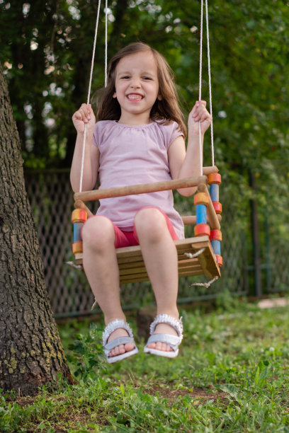 一个四岁小女孩在后院荡秋千图片下载