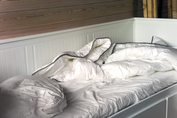 未整理的床和皱巴巴的被褥图片下载