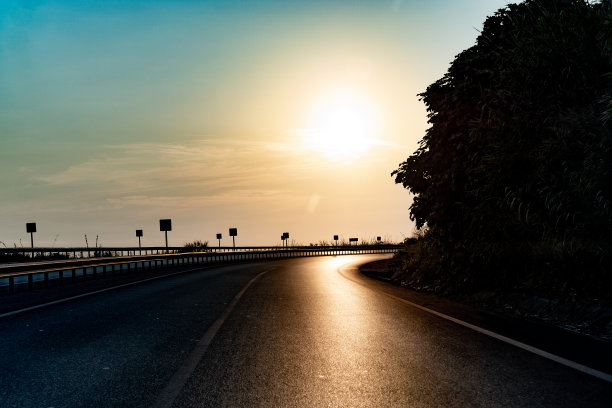 夕阳下弯弯曲曲的两车道公路图片下载