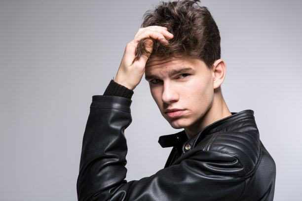 护发、健康、养生理念。肖像自信，有魅力的男人触摸手，调整发型。男性头发健康理念。年轻的时尚模特与突出的发型图片下载