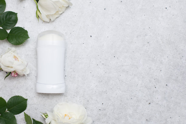 女人用的除臭剂，灰色的桌子上放着白玫瑰图片下载