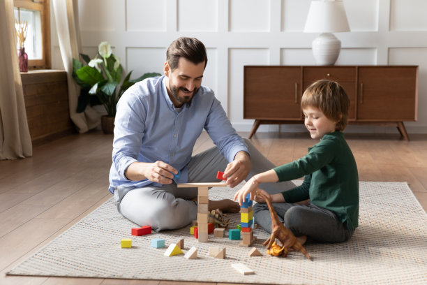快乐的父亲和小儿子在温暖的地板上玩耍图片下载