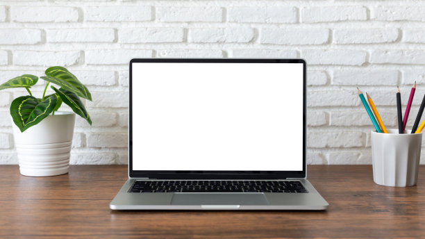 白色屏幕的笔记本电脑，木桌上有工作空间和办公用品图片下载