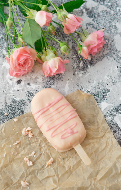 冰淇淋棒棒糖蛋糕在灰色背景和鲜花。选择性聚焦，复制空间图片下载