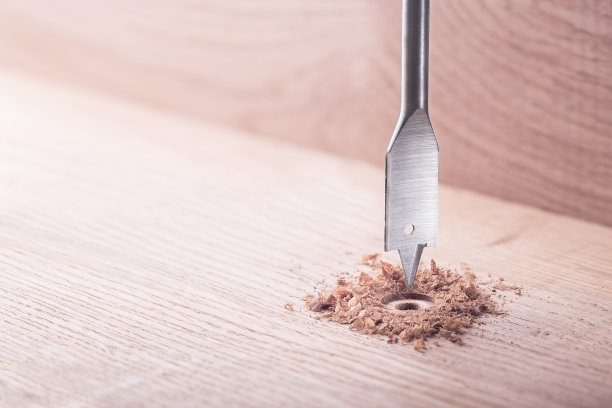 金属钻头桨在橡木木板上钻洞图片下载