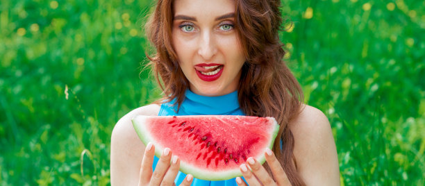 可爱的女人拿着一块西瓜。图片下载