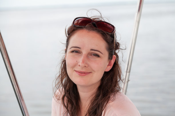 美丽的棕色头发的女人在模糊的背景上穿粉红色的衬衫图片下载