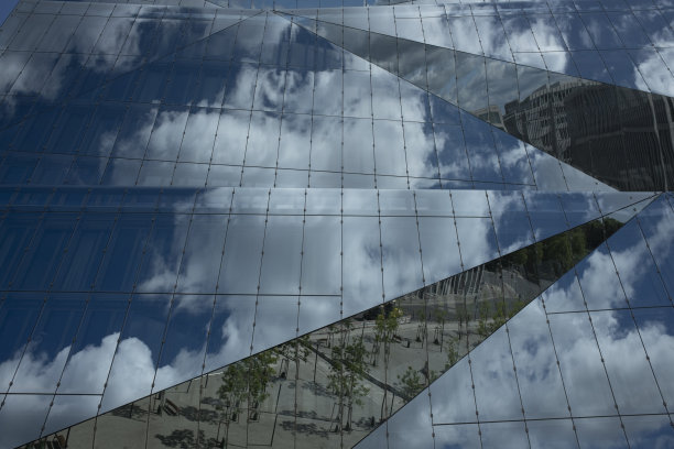 云的天空反射在现代办公建筑的玻璃立面上图片下载