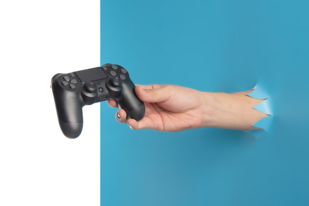 游戏概念，手持新操纵杆通过撕破的蓝色塑料隔离在白色的背景图片下载