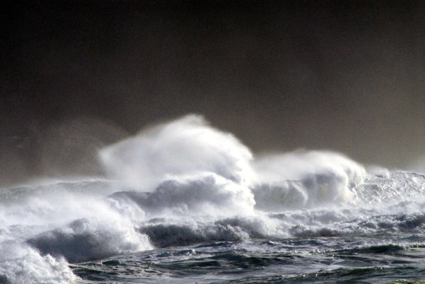 新西兰-狂暴的冲浪对抗暴风雨的黑暗天空图片下载