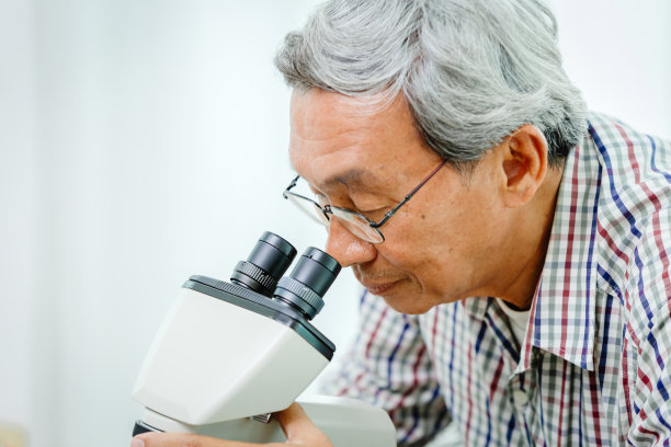 在医院实验室观察显微镜进行病毒医学研究的亚洲华人医生图片下载
