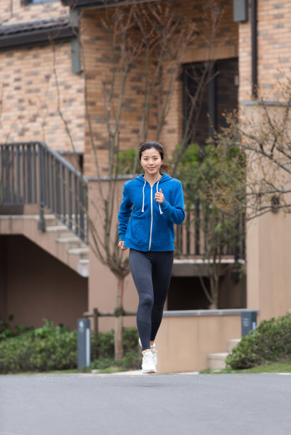 一个年轻的亚洲女人在社区慢跑图片下载