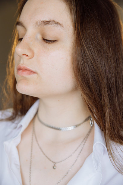 一个漂亮的黑发女孩抬起小鼻子望着别处。图片下载