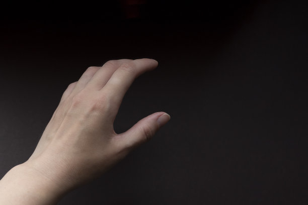 棕色背景上的女性手。关闭了。手显示大小手势。图片下载