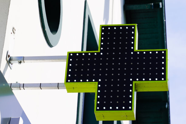 药店在华尔街大楼的绿十字标志图片下载