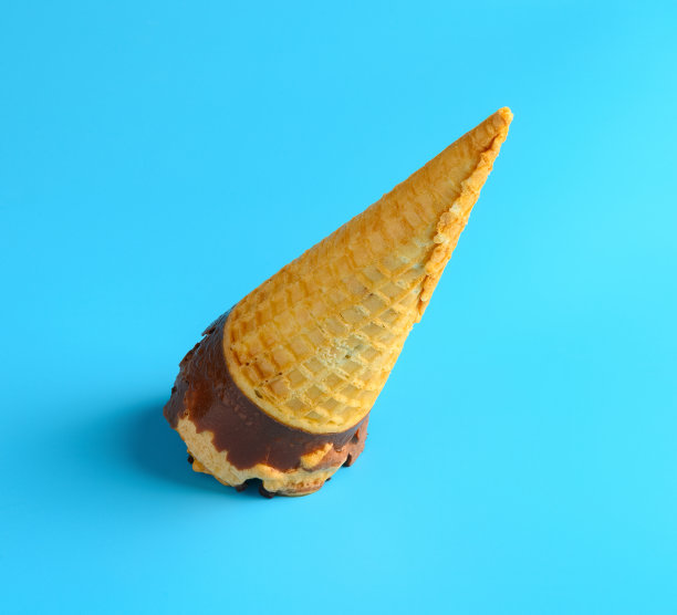蓝色的背景下，巧克力和咖啡口味的蛋卷开始融化图片下载