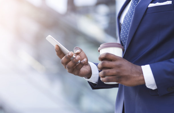 在城市里，一个陌生的商人拿着咖啡在手机上发短信图片下载