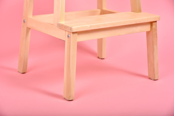 极简的室内风格，粉彩背景上的木椅腿，极简主义家具。图片下载