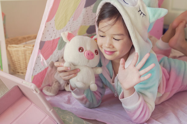 混血亚洲女孩在家里用平板电脑做facetime视频通话，使用缩放学习在线应用程序，社会距离，隔离，家庭学校教育，学习远程概念图片下载