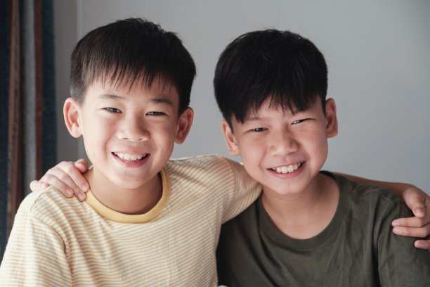 快乐的亚洲男孩微笑和拥抱彼此，十多岁的男孩肖像，友谊图片下载