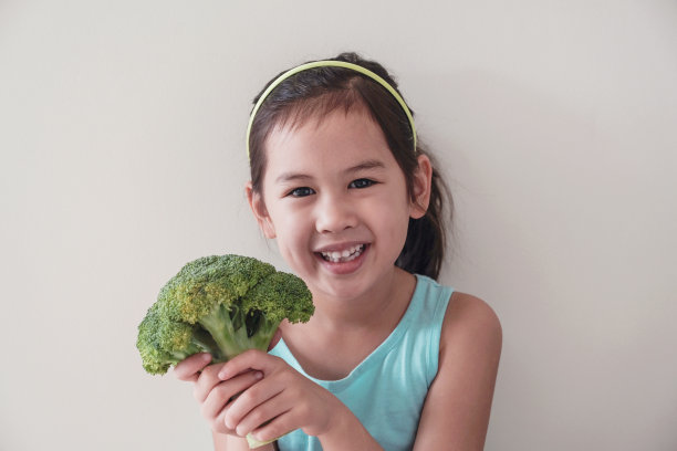 快乐和健康的混合亚洲女孩抱着花椰菜，儿童健康，素食健康的食品概念图片下载