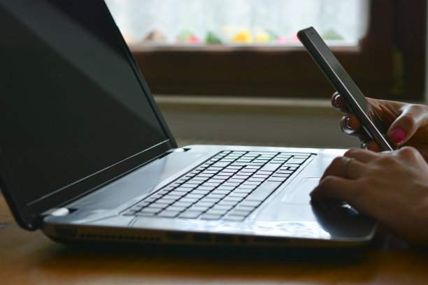 女孩的手在电脑和电话上图片下载