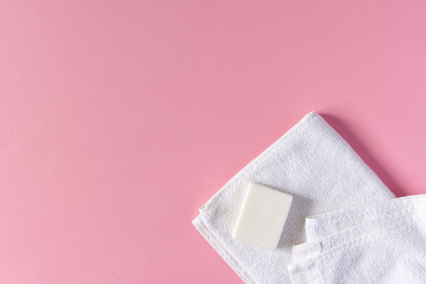 粉色背景上带肥皂的毛巾图片下载