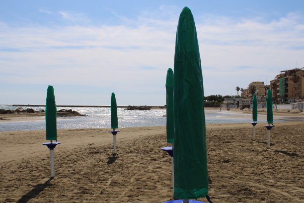 沙滩上的伞人们在夏天沙滩季节坐在沙滩上用这些伞图片下载