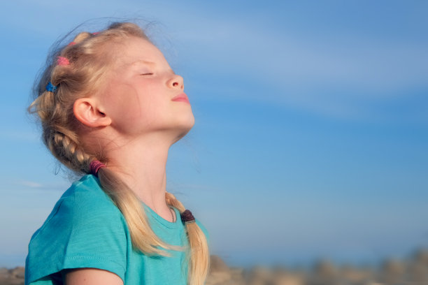 放松的女孩呼吸新鲜的空气在蓝色的天空，在夏天的海上。梦想、自由和旅行的概念图片下载