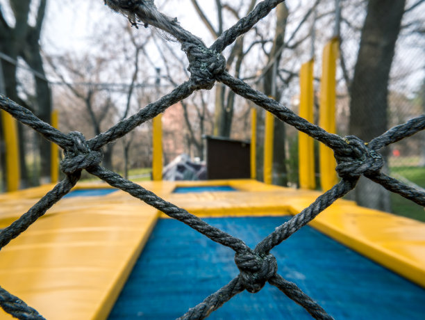 近距离的栅栏缠绕网格与模糊的背景。图片下载