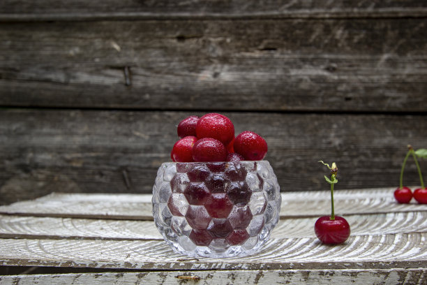 多汁的樱桃放在一个多叶的花瓶里图片下载