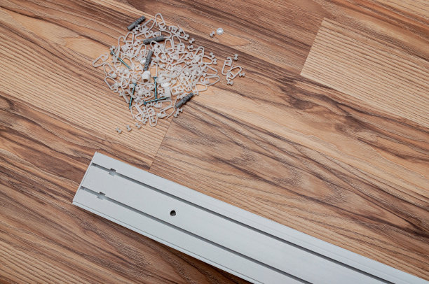 铺在地板上的窗帘杆和窗帘扣件图片下载