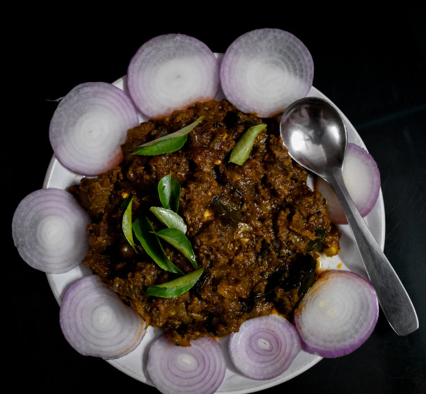 南印度美食喀拉拉邦风格的牛肉炒/烤。传统的烤肉方式。配以洋葱片和咖喱叶。黑色背景。选择聚焦的照片。图片下载
