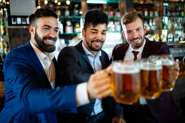年轻的商人们在酒吧里喝着啤酒，谈笑风生图片下载