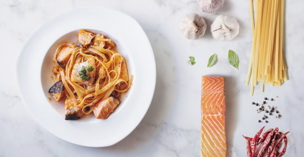 俯视图，用新鲜的食材炒香辣三文鱼面，白色大理石的纹理图片下载