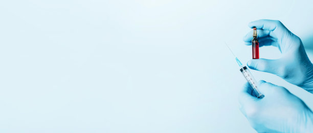 医学、注射和疫苗概念。双手戴医用手套，手持注射器和安瓿，蓝色背景。副本的空间。冠状病毒大流行隔离期间的卫生防护设备图片下载
