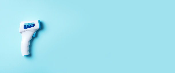 数字医用红外非接触测温枪，用于冠状病毒COVID-19检测的蓝色背景温度测量。医学概念。检疫传染病。保持安全图片下载
