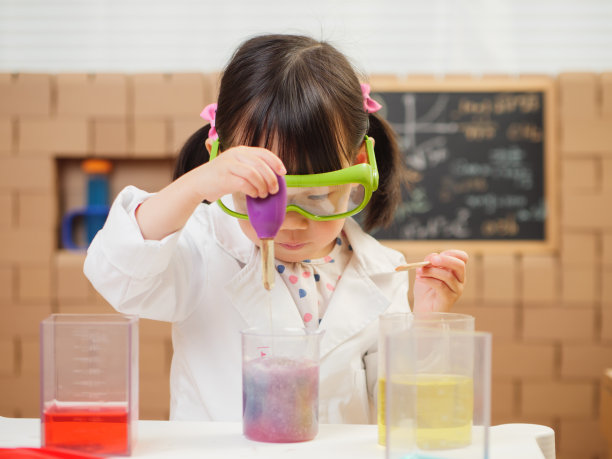 蹒跚学步的女孩假装扮演科学家角色在家上学图片下载