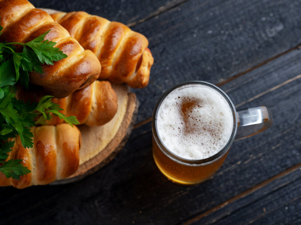 马克杯里的小麦淡啤酒和生面团里的自制香肠图片下载